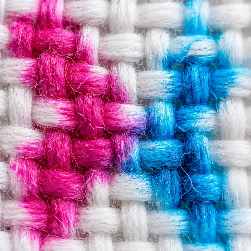 Close-up of a woven fabric dyed magenta and cyan